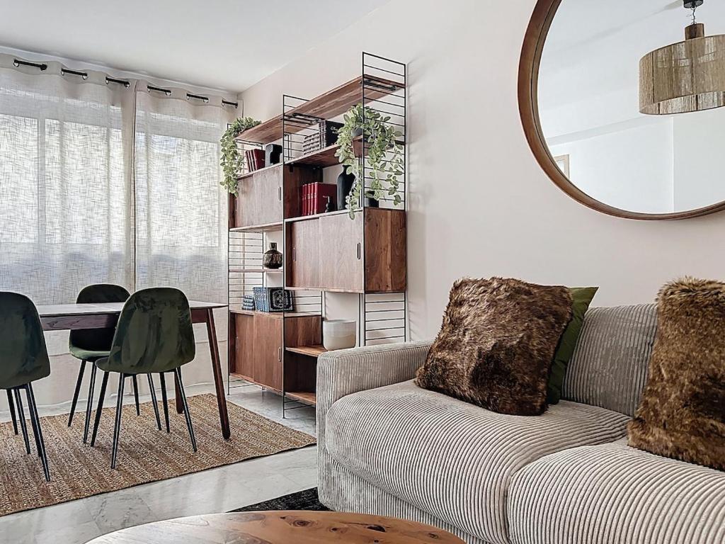 un salon avec un canapé, une table et un miroir dans l'établissement Appartement climatisé, 2 chambres, plage Mourillon, à Toulon
