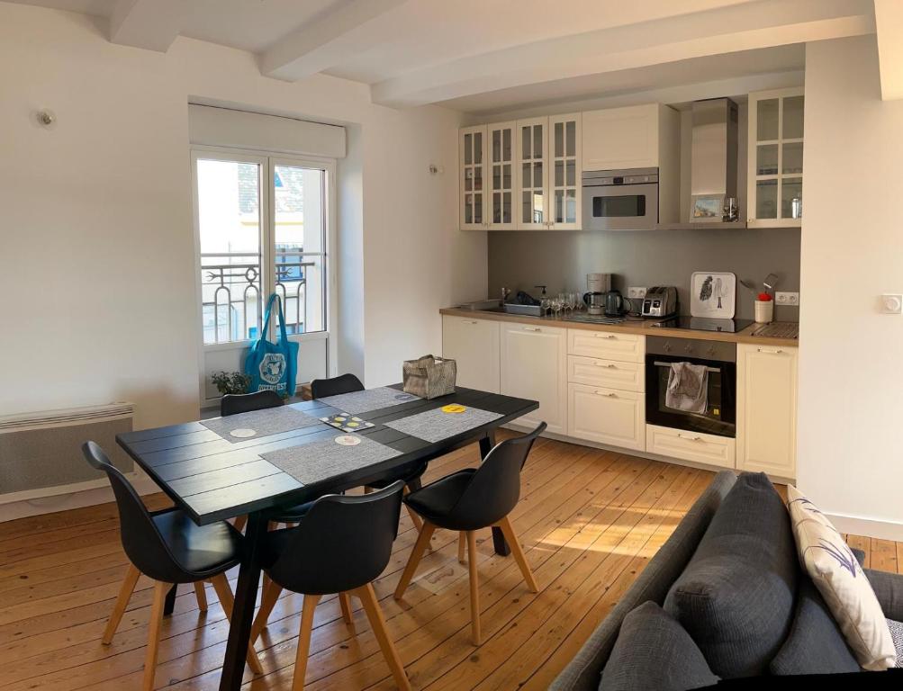 une cuisine et un salon avec une table et des chaises dans l'établissement Duplex au cœur de Paramé, à Saint-Malo