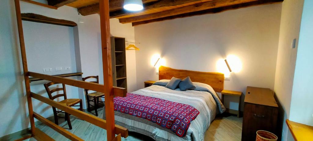 a bedroom with a bed and a staircase with two lights at CA' DEL PITUR Apartments B&B Cicogna in Cicogna