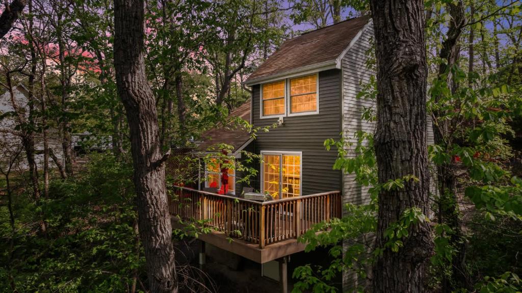 a small house with a deck in the woods at Secret Gardens Fireplace Deck & Dog-Friendly in Inwood