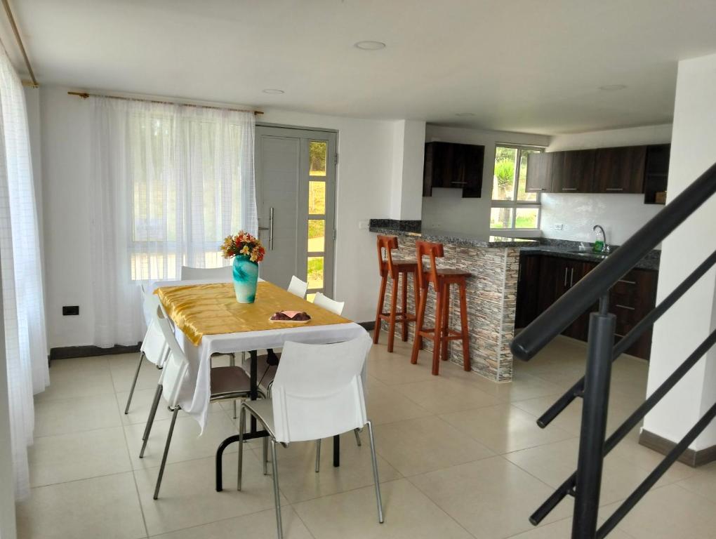 una cucina e una sala da pranzo con tavolo e sedie di Villa Graciela II a Paipa