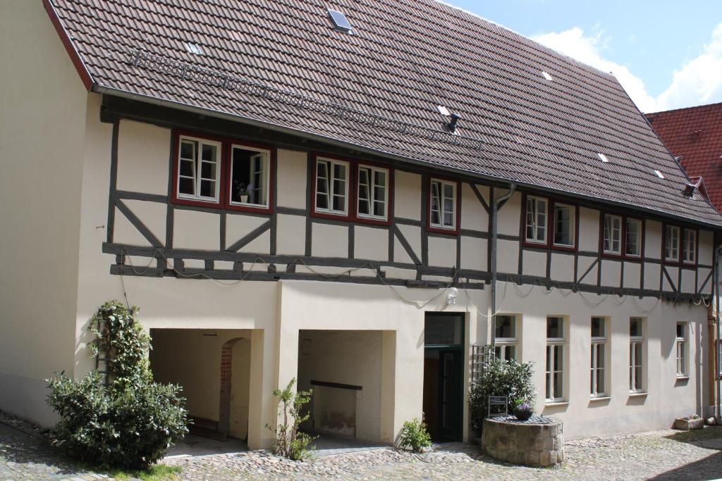 ein großes weißes Gebäude mit schwarzem Dach in der Unterkunft Ferienwohnungen Im Alten Handelshof in Quedlinburg