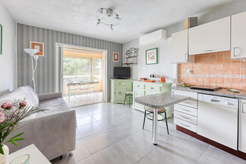 - une cuisine avec un canapé et une table dans une chambre dans l'établissement L'Alisier - climatisé à 5 min de la plage, à Six-Fours-les-Plages