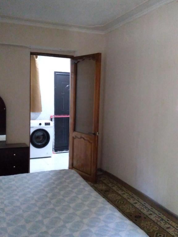 an empty room with a bed and a door to a kitchen at Двухкомнатная квартира in Kutaisi