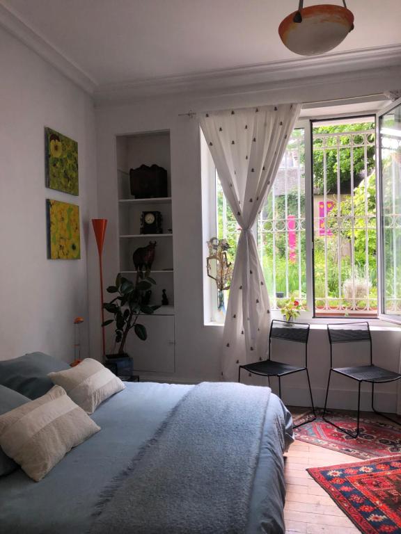 une chambre avec un grand lit et une fenêtre dans l'établissement Noctuelle, à Bourges