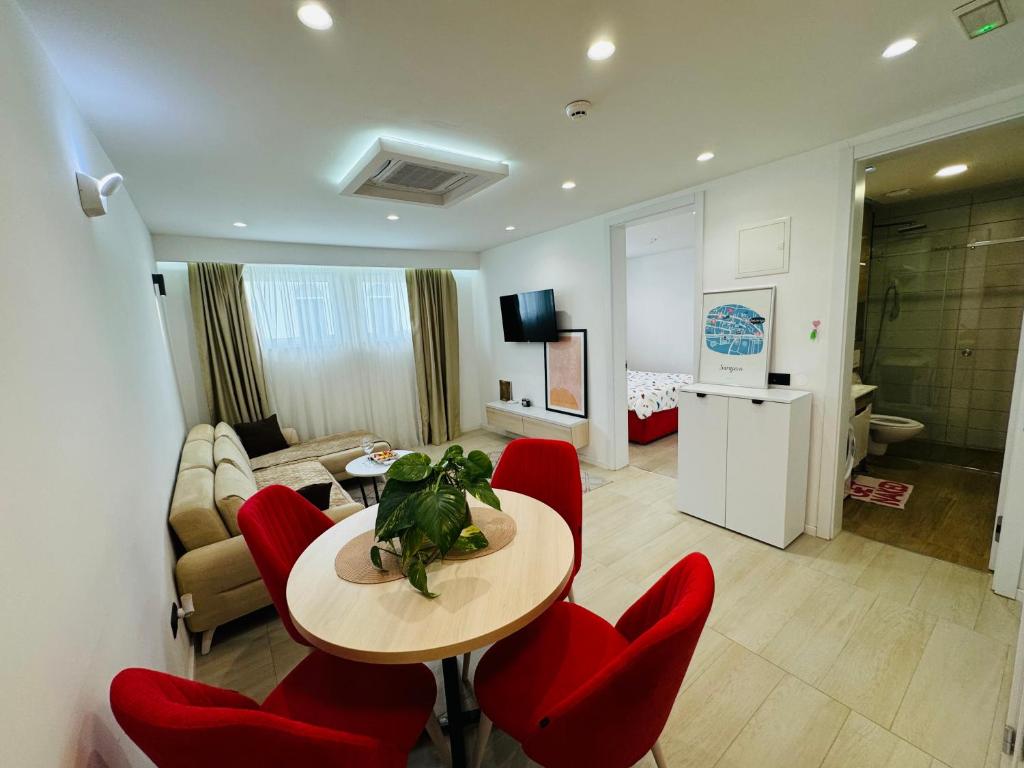 ein Wohnzimmer mit einem Tisch und roten Stühlen in der Unterkunft The pearl residence Sarajevo - Bascarsi - Walk everywhere in Sarajevo