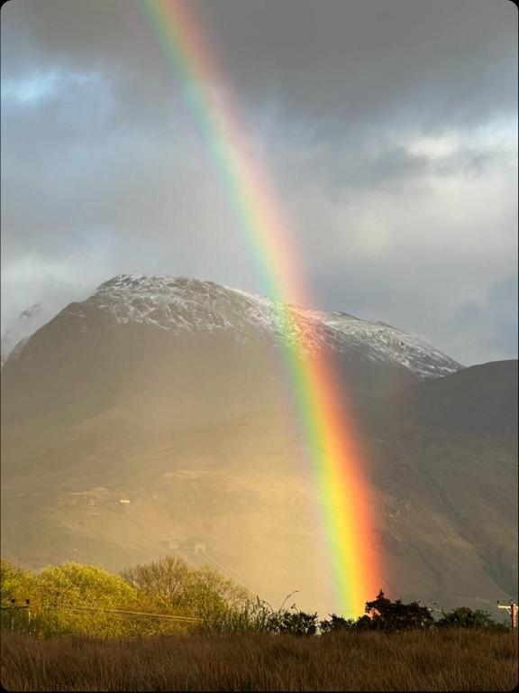 a rainbow in the sky with a mountain in the background at Croft cabin in Fort William