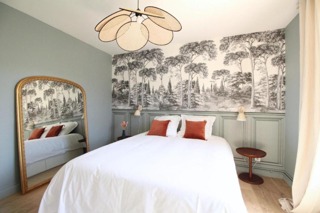 - une chambre avec un lit blanc et une fresque murale dans l'établissement L'élégance aux portes des caves, à Reims