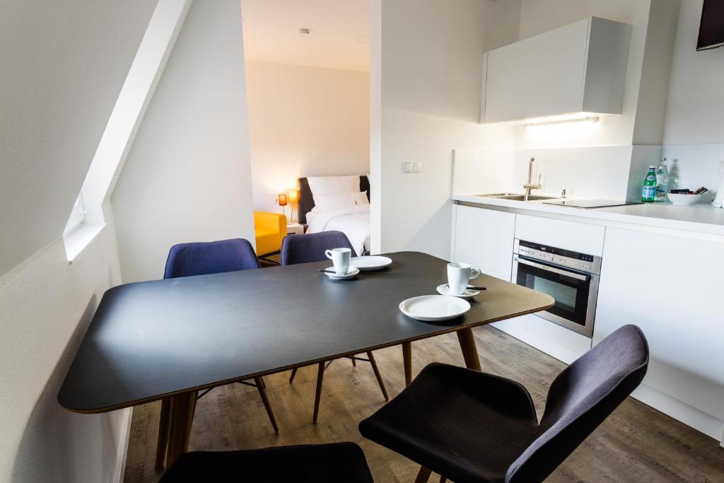 een kleine keuken en eetkamer met een tafel en stoelen bij Apartmenthaus Königsallee in Bayreuth