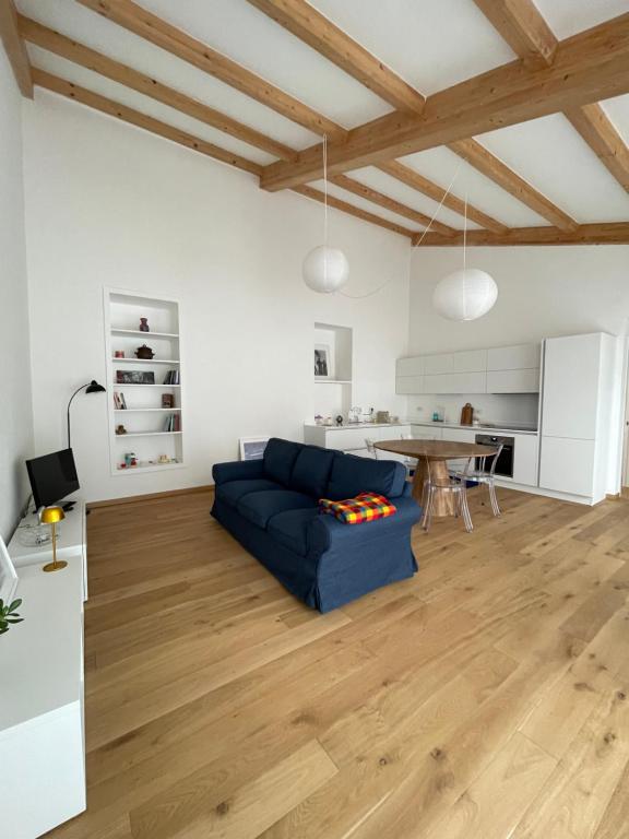 Una sala de estar con un sofá azul y una mesa. en Le finestre sul cortile Biella, en Biella