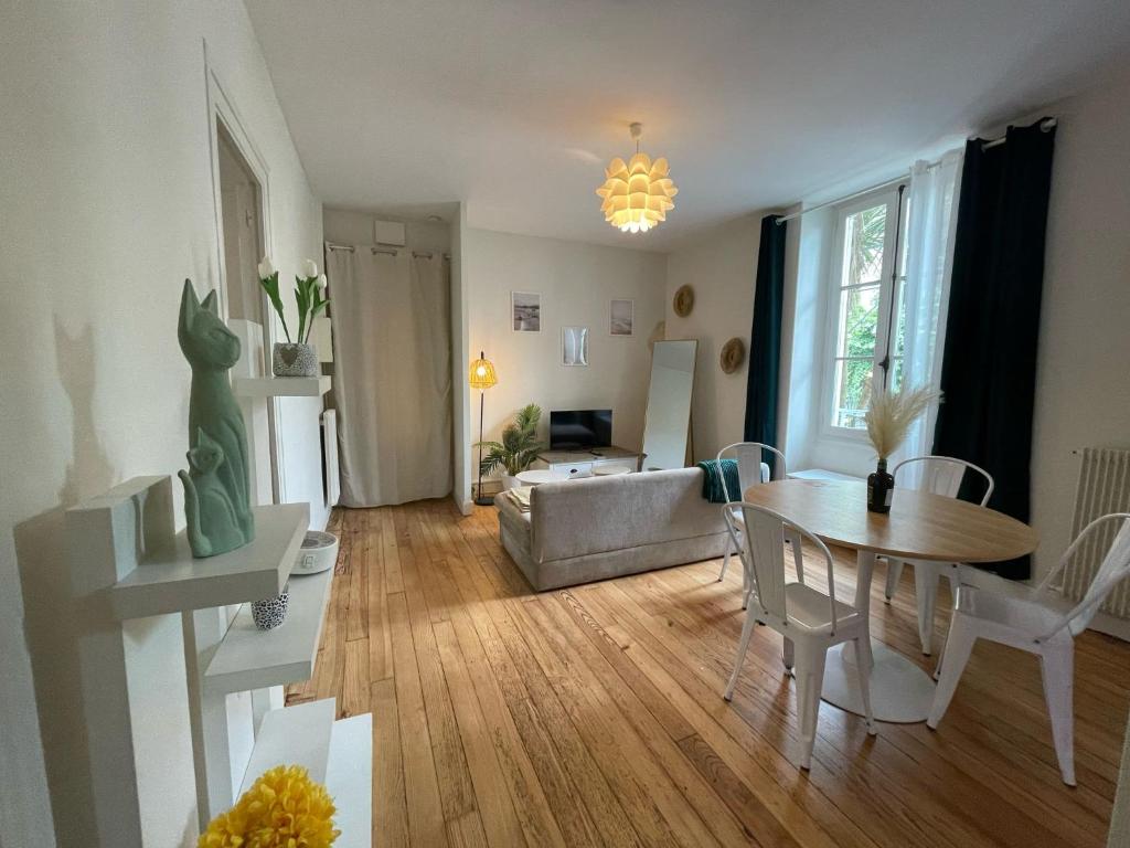un salon avec une table et un canapé dans l'établissement Cosy Amber - 2CH - Place Verdun & Parking, à Pau