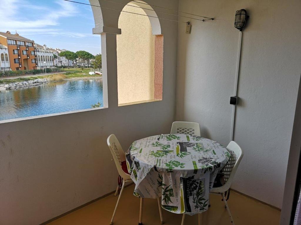 une table et des chaises dans une pièce avec une fenêtre dans l'établissement Appartement T2 Cabine - 6 pers, Parking - Le Barcarès - FR-1-195-83, au Barcarès