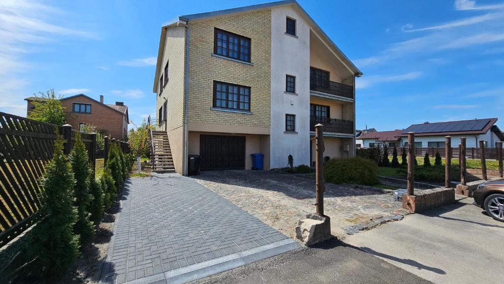 a large house with a driveway in front of it at Guest house Sunrise in Šiauliai