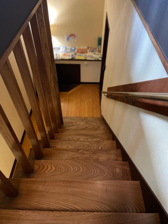 a stairway with wooden treads in a room at Guest House BONITO in Kochi