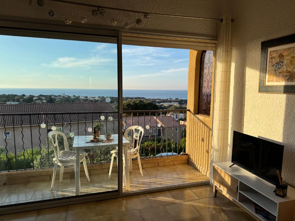 un patio con tavolo e sedie su un balcone di Studio 1 pièce 3 couchages MARINE DE SANT AMBROGGIO a Lumio