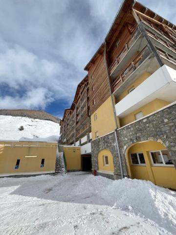 un bâtiment avec de la neige devant lui dans l'établissement Appart 6 pers avec piscine, à Allos