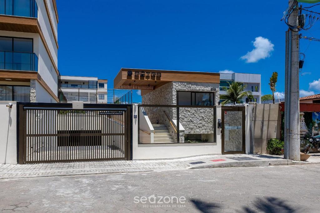 un edificio con cancello di fronte a un edificio di Aptos em Cond. c/ piscina à Beira da Praia em Ilhéus - PET a Pontal