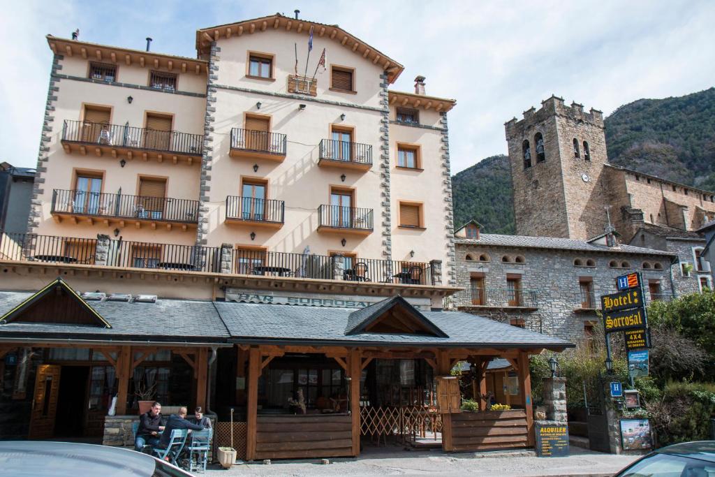 un gran edificio con una torre de reloj delante de él en Sorrosal, en Broto