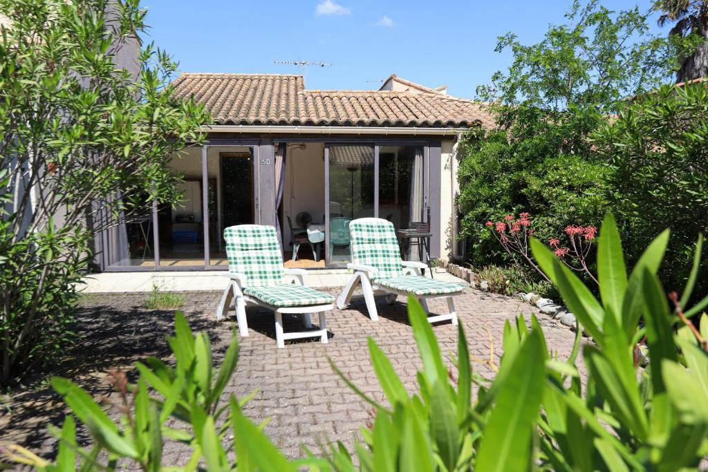 deux chaises et une table devant une maison dans l'établissement St Cyprien Maison 4p avec grande terrasse et jardin clos, à Saint-Cyprien