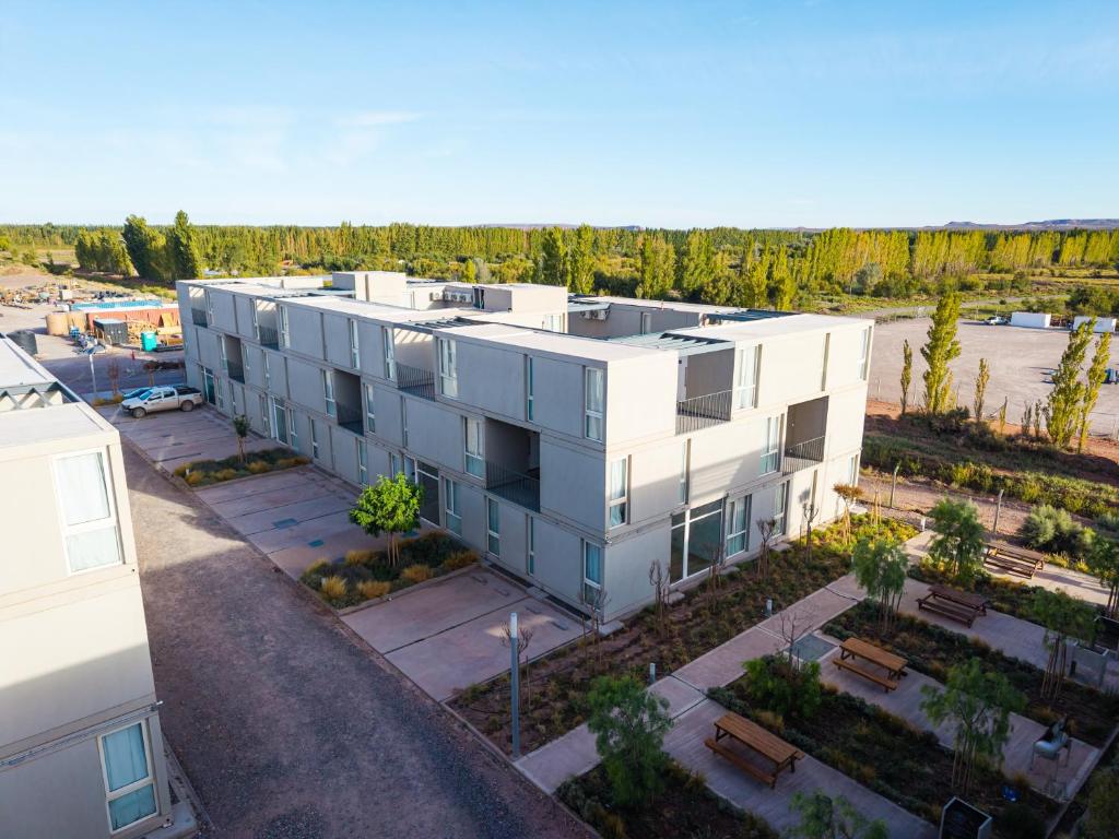 an aerial view of a white building with a parking lot at Añelo Nuevo Housing in Añelo
