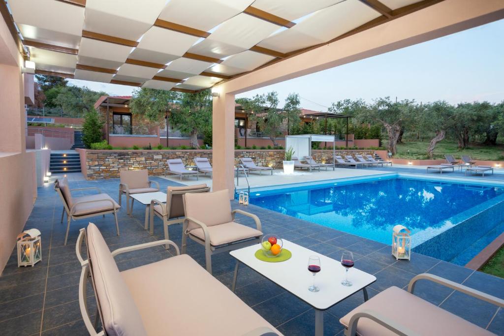 - une terrasse au bord de la piscine avec des tables et des chaises dans l'établissement Aventura Village, à Potos