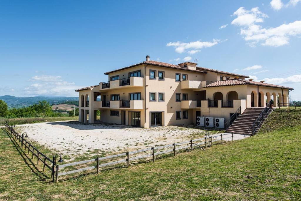 a large house on a beach with a fence at Residenze Pianetti in Manciano