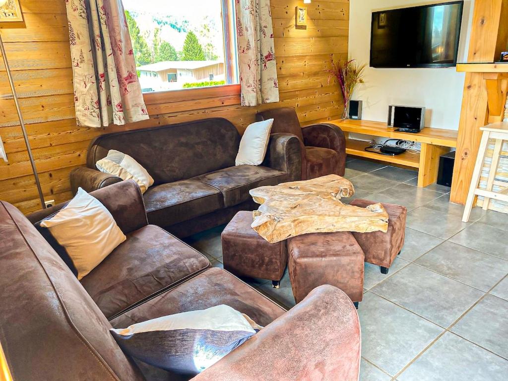 un salon avec des canapés, des tables et une télévision dans l'établissement Chalet le Lynx quiet vacation, à Xonrupt-Longemer