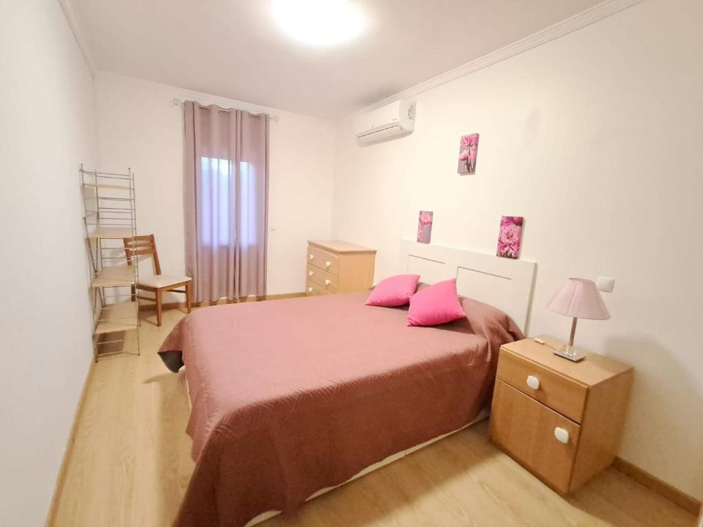 a bedroom with a large bed with pink pillows at Apartamento T3 sta luzia in Santa Luzia