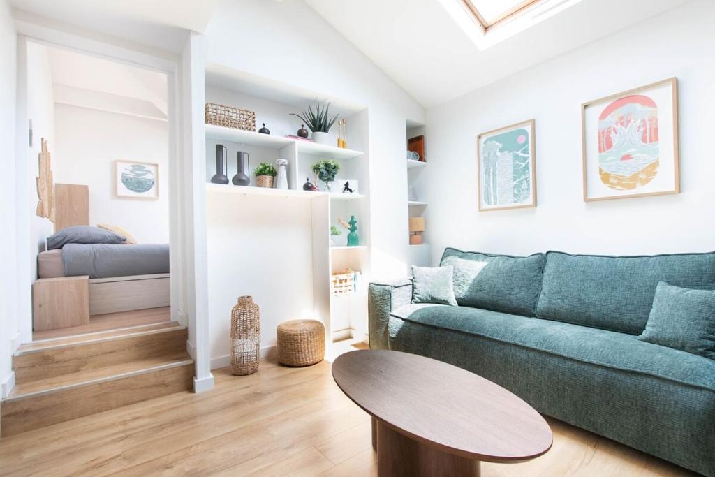 a living room with a green couch and a table at Le Marco Polo in Soorts-Hossegor