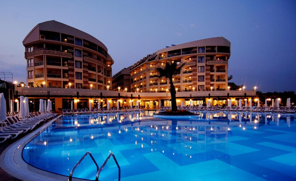 シダにあるSeamelia Beach Resort Hotel & SPAの2棟の建物の前にスイミングプールがあります。