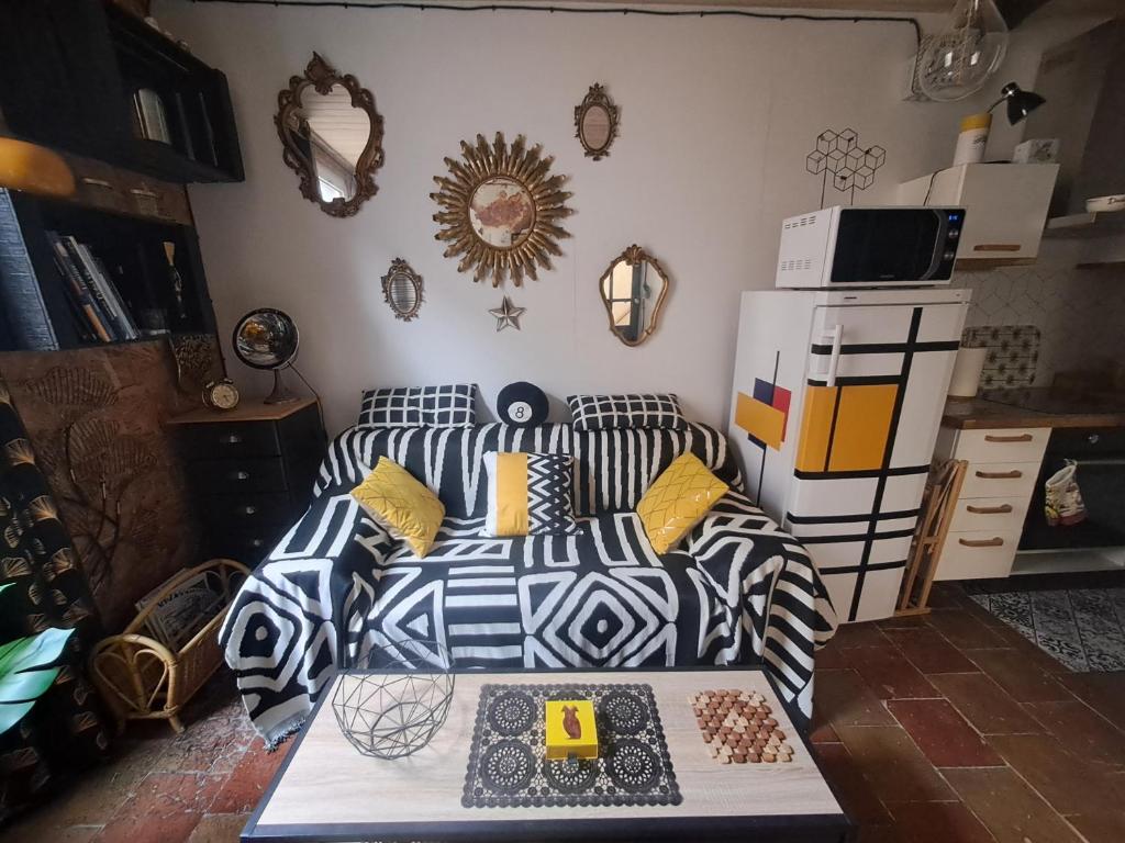 une chambre avec un lit avec des oreillers noirs et blancs dans l'établissement Le Lodge Keraën, à Clermont-lʼHérault