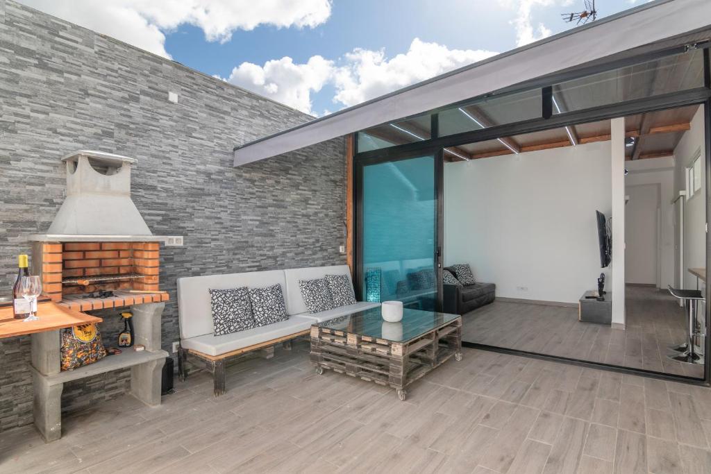a patio with a couch and a fireplace at La Lajita in Tafira Baja