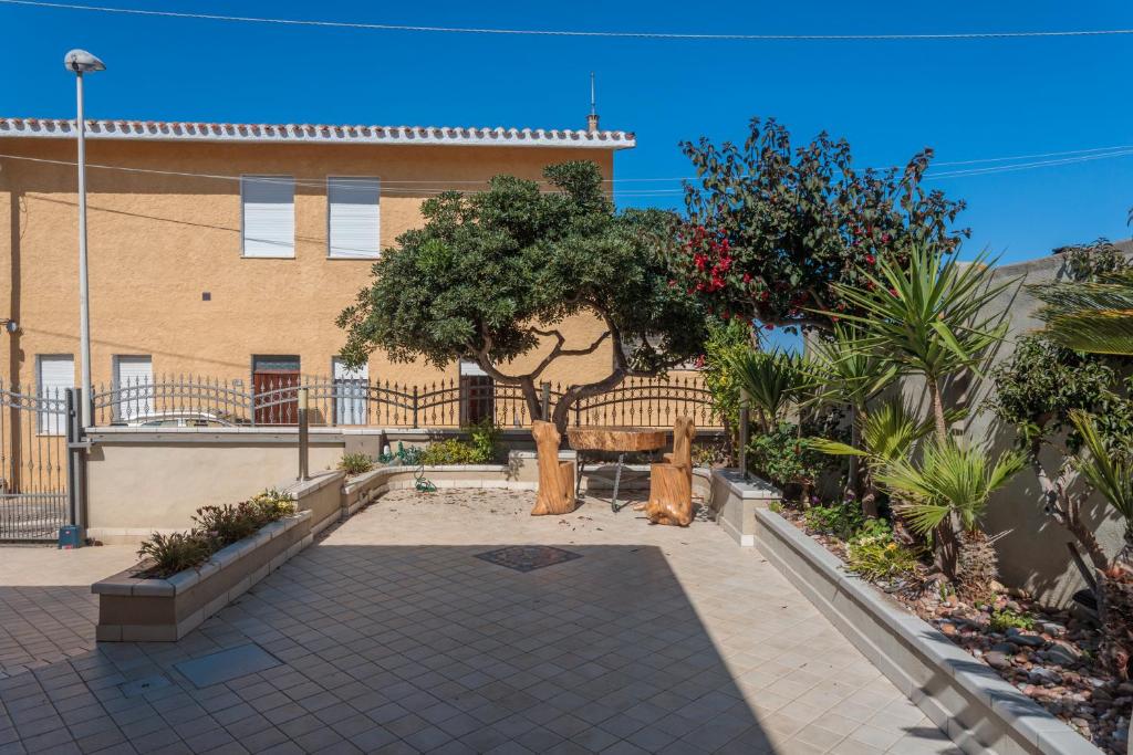 a park with a bench in front of a building at Villetta Al Mare - S'archittu in S'archittu Cuglieri