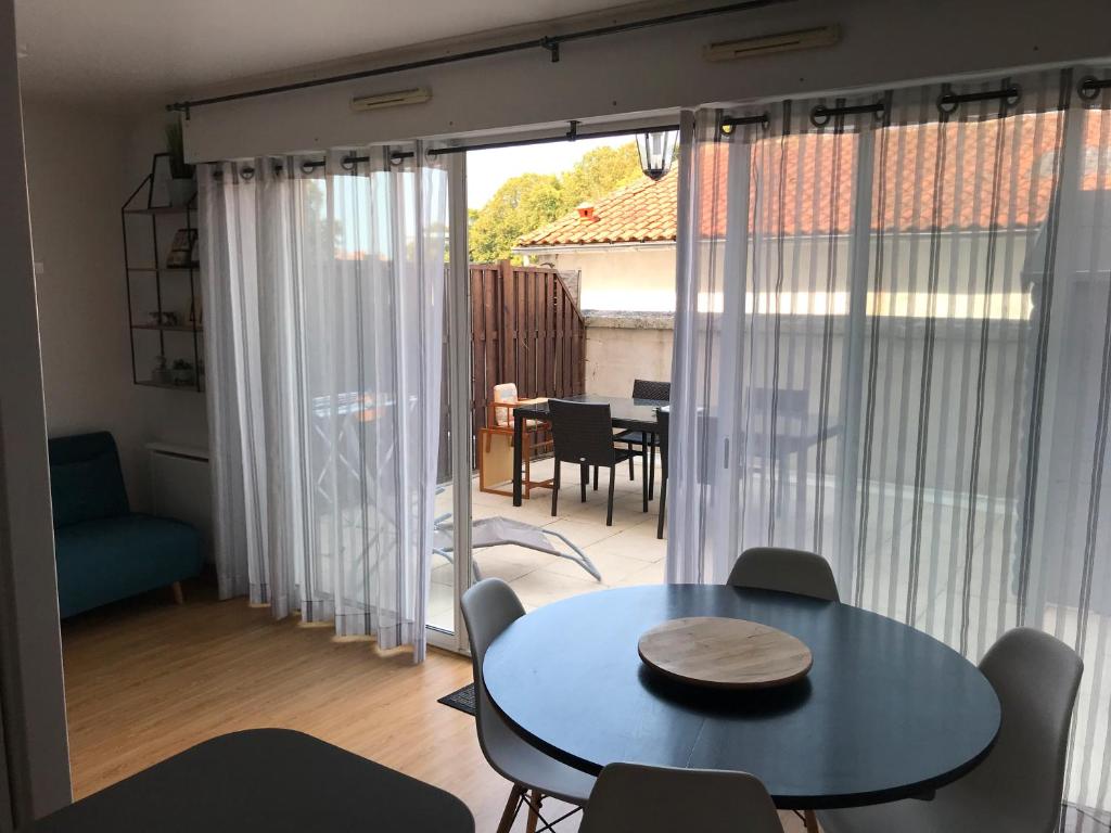 d'un salon avec une table et des chaises ainsi que d'une terrasse. dans l'établissement Appartement Le Saint-François, à La Rochelle