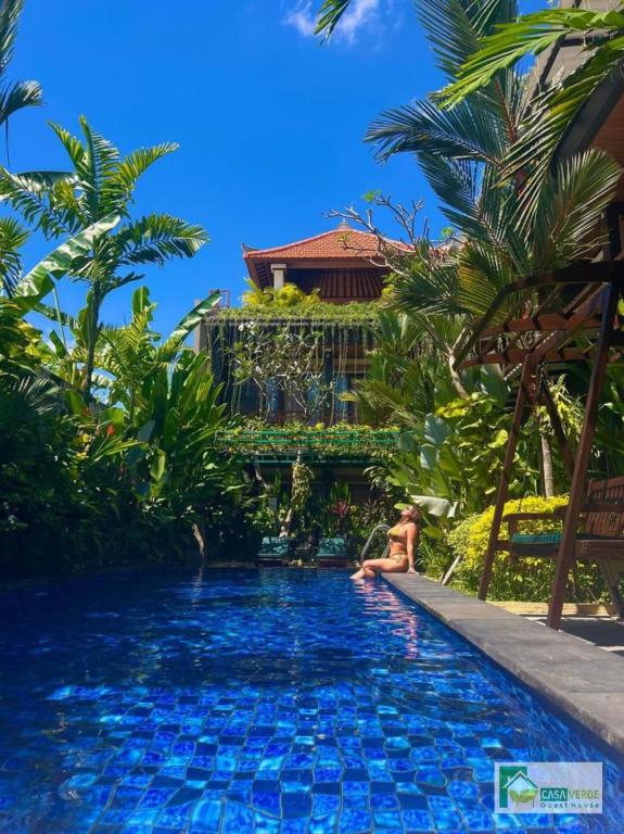 a woman sitting in a pool at a resort at Casa Verde Guest House in Sempidi