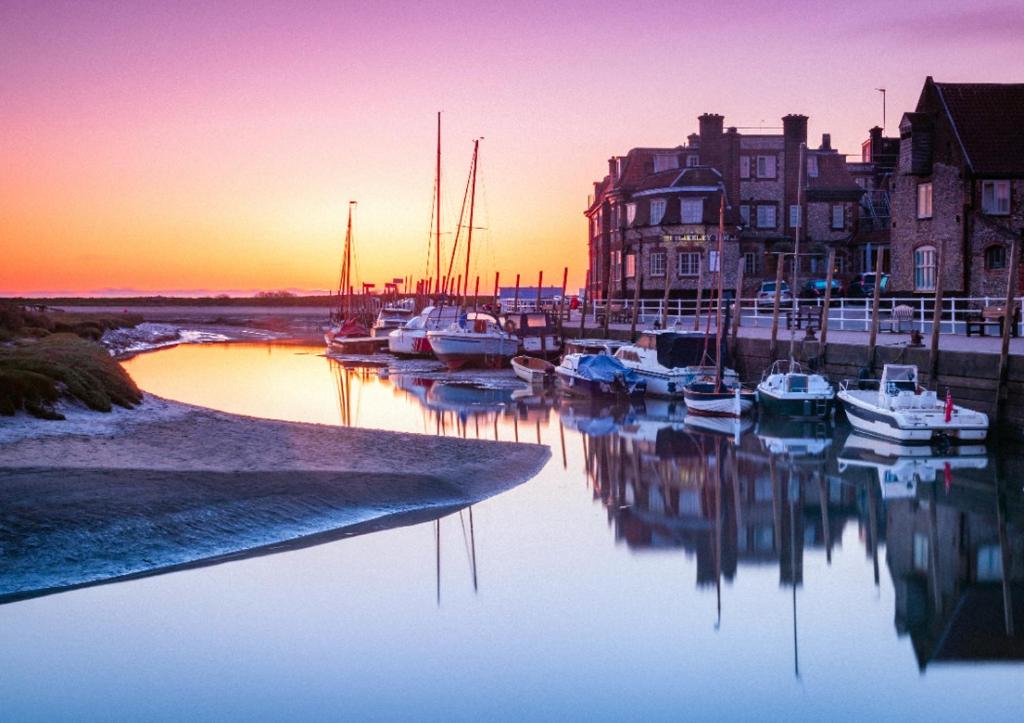 a group of boats docked in a marina at sunset at Bramble Lodge in Blakeney