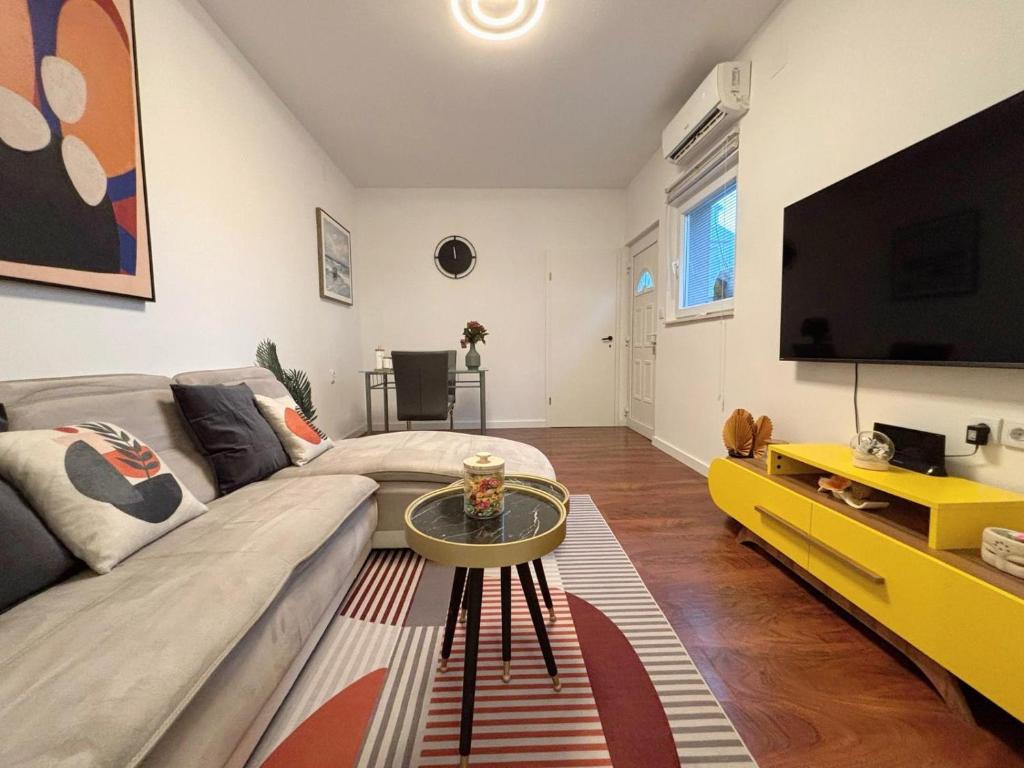 een woonkamer met een bank en een tv bij Apartment Nino in Zadar