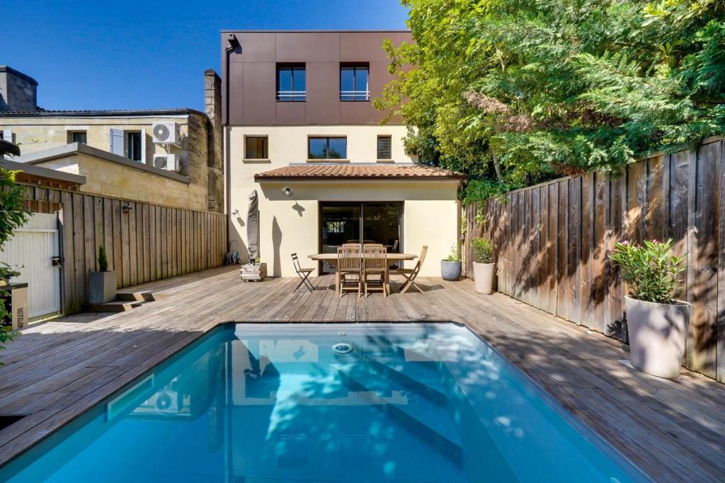 une cour arrière avec une piscine et une terrasse en bois dans l'établissement Beautiful house in Le Bouscat with pool & parking, à Le Bouscat