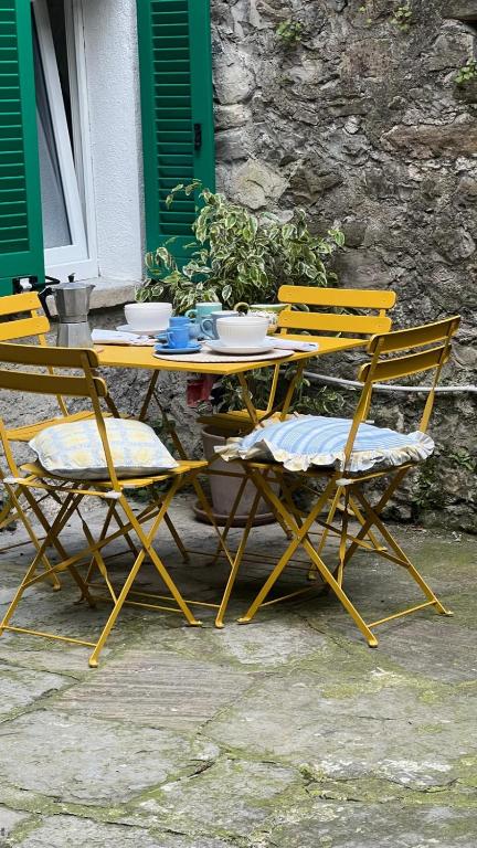a table and chairs with bowls and plates on it at Casa Caterina in Lezzeno