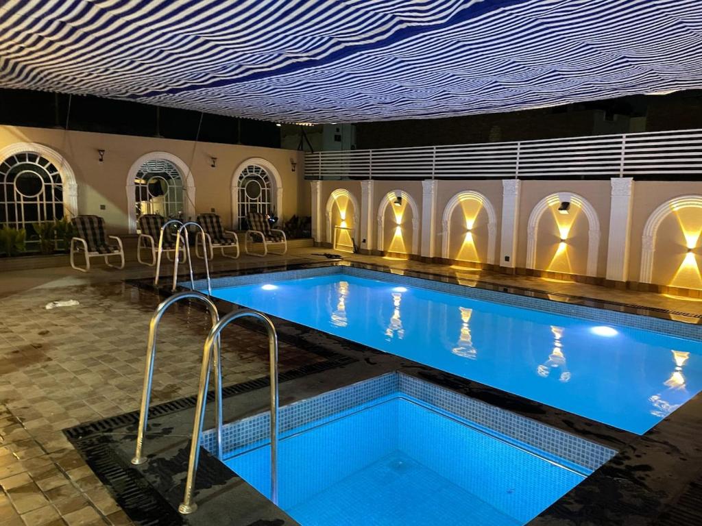 a large swimming pool with blue water in a building at ASNB Residence in Multan