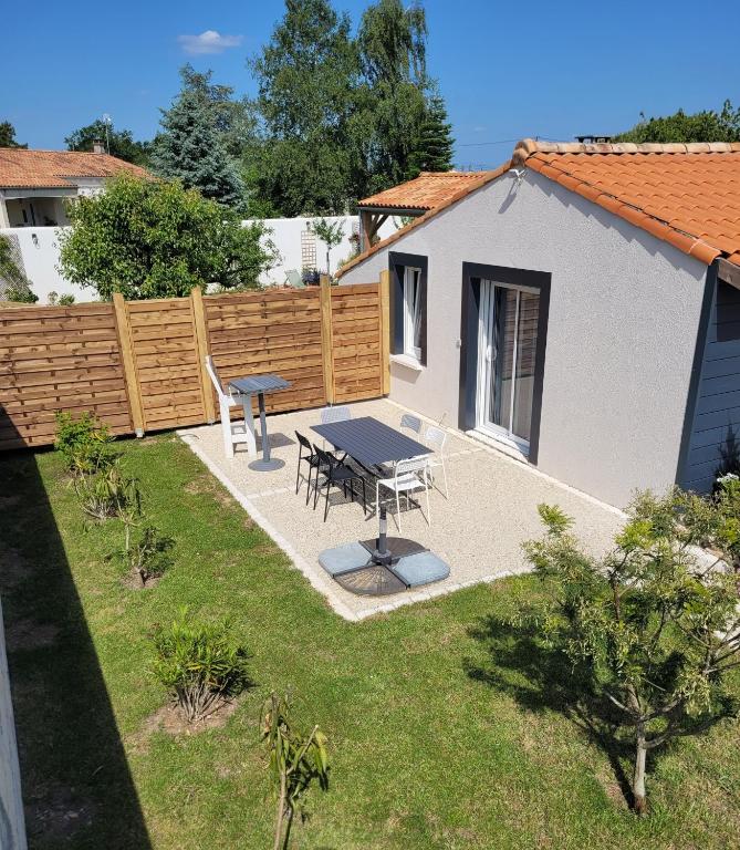 a backyard with a picnic table and a fence at coquet petit studio in Chaillevette