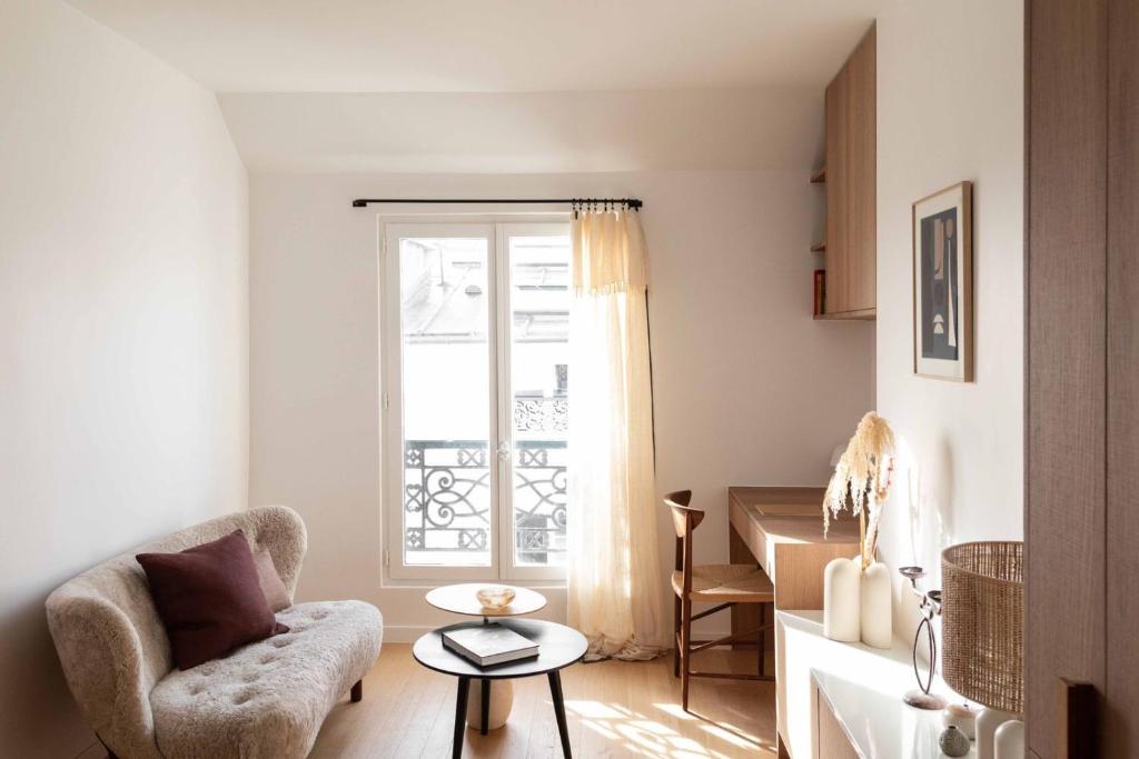 a living room with a chair and a window at Disney-Paris Appartement - Gare in Bussy-Saint-Georges