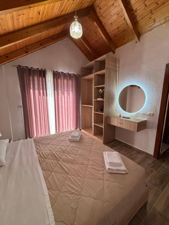 a bedroom with a large bed and a mirror at P&K apartment Pogradec in Pogradec