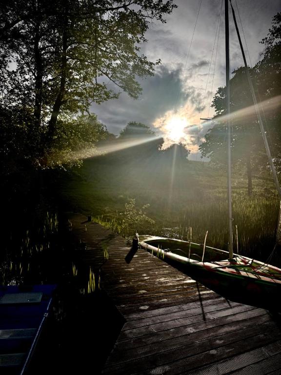 a boat on a dock with the sun in the sky at Mylin in Chrzypsko Wielkie
