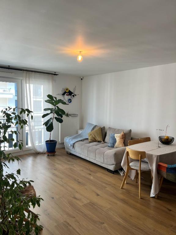 un salon avec un canapé et une table dans l'établissement Nid douillet équipé à Saint-Ouen, à Saint-Ouen