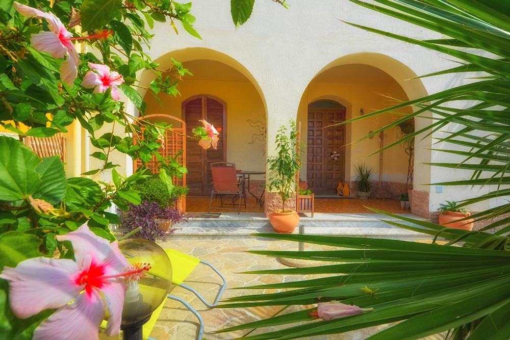 un cortile di una casa con piante e fiori di Baia Tono Home a Milazzo