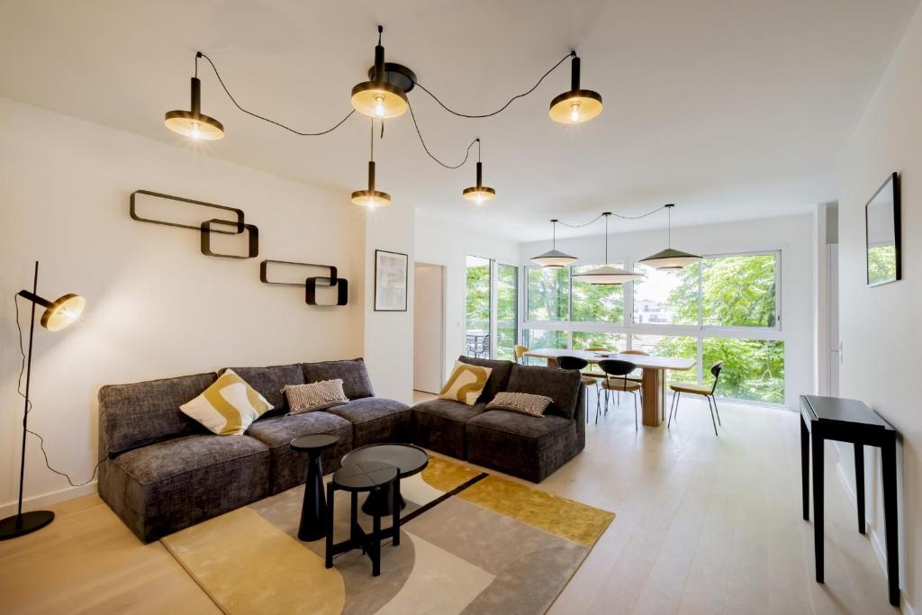 un salon avec un canapé et une table dans l'établissement Spacious 4BR with Lovely Balcony, à Bordeaux