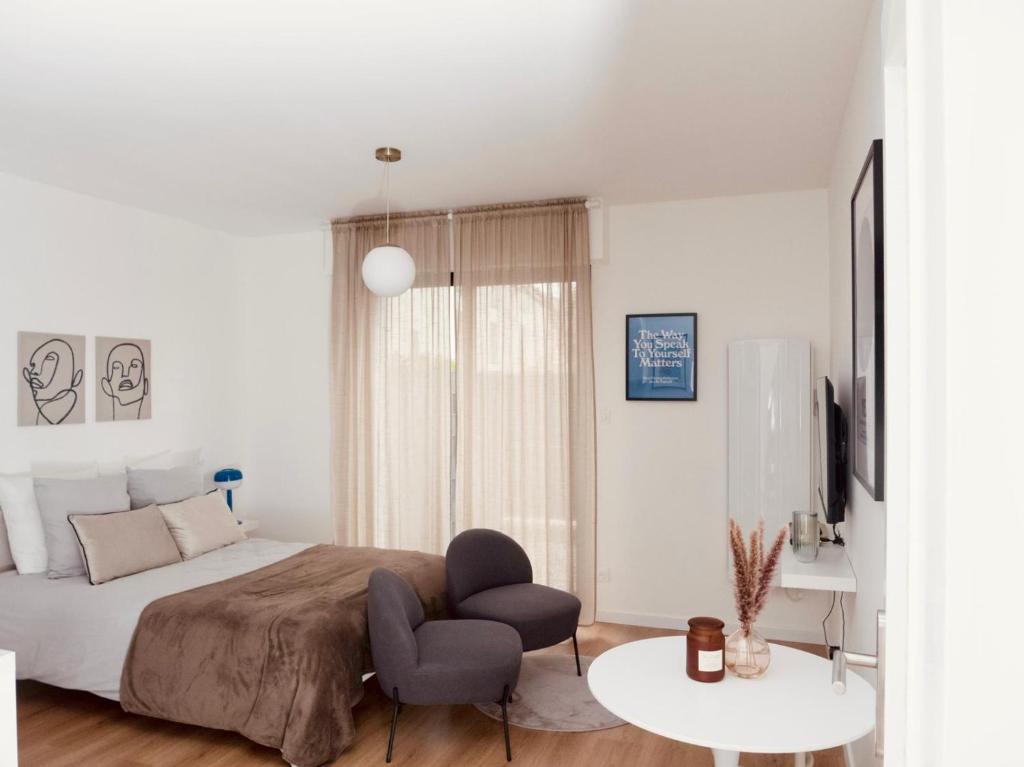 une chambre avec un lit, une chaise et une table dans l'établissement Le signature - Magnifique Studio tout confort au coeur de Strasbourg, à Strasbourg