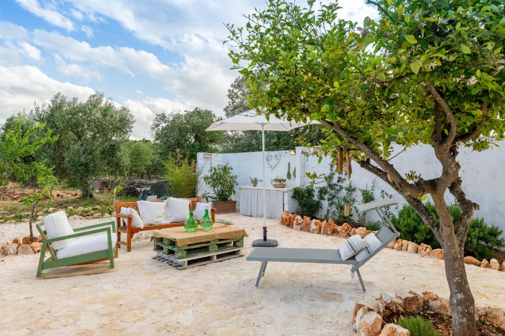 a patio with two chairs and an umbrella at La Casita Ostuni - Authentic Apulian Stay in Ostuni