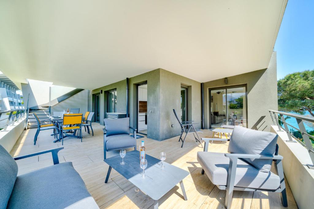 d'une terrasse avec des chaises et des tables sur un balcon. dans l'établissement Rooftop 3 pièces avec Piscine face mer, à Villeneuve-Loubet